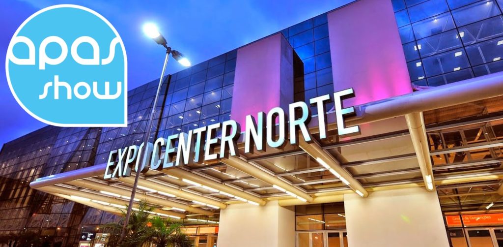 Foto da entrada de um centro empresarial com o nome escrito em forma de placa. Na placa esta escrito "EXPOCENTER NORTE" com letras maiúsculas. As paredes do local são revestidas de vidro podendo ver o lado de dentro.